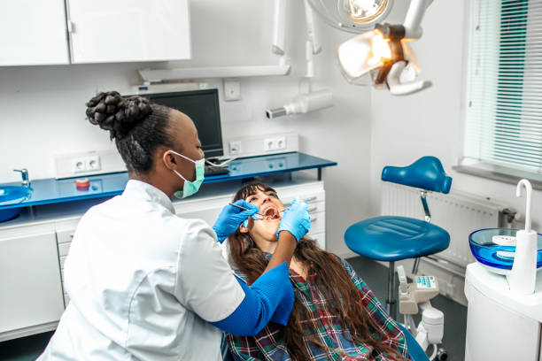 Black female dentist with a young female patient in her surgery stock photo