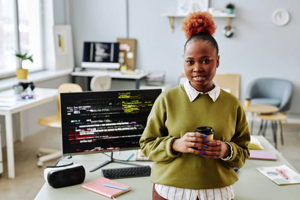 istock Black young woman as software programmer smiling at camera in office 1468187383