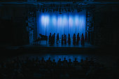 in silhouette choir getting ready on stage theatre