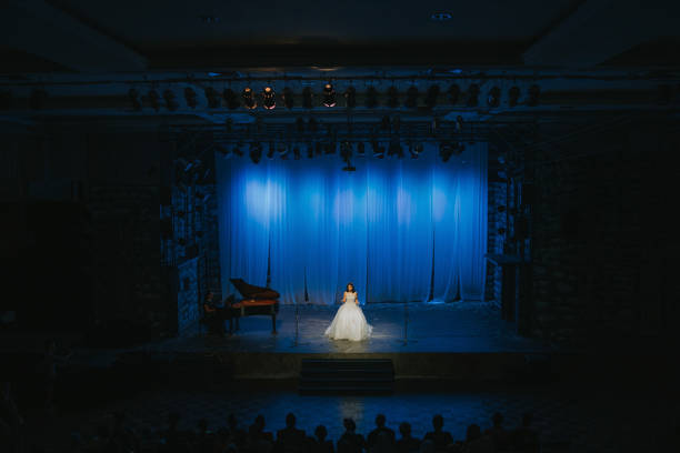 Young Chinese Female opera singer performing solo on stage with Pianist Young Chinese Female opera singer performing solo on stage with Pianist theater industry stock pictures, royalty-free photos & images