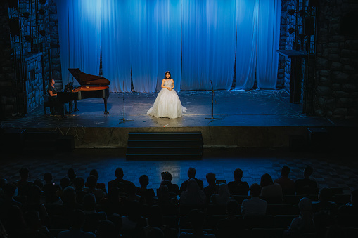 A young woman singer in silhouette on stage during a concert