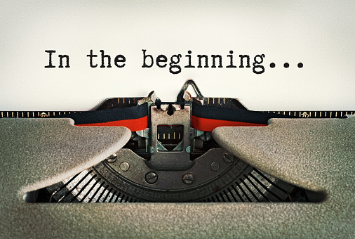 In The Beginning, says beginning of story on a page in an old-fashioned retro typewriter