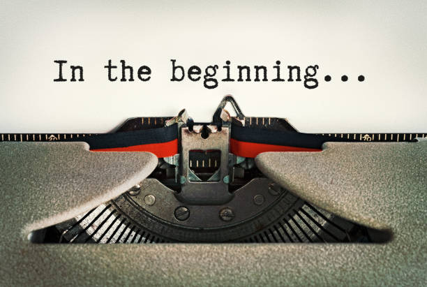 In The Beginning, says beginning of story on a page in an old-fashioned retro typewriter Typescript in an old typewriter reads "In the beginning...", the first words of the Book of Genesis in the Bible. typebar stock pictures, royalty-free photos & images