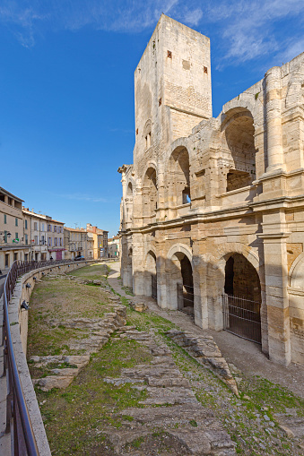 View on the roman amphitheatre, with a matador statue in foreground, in the centre of Nîmes city,  in France. October, 25, 2022.