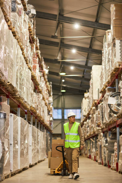 istock Female worker carrying boxer in warehouse walking towards camera 1468190907