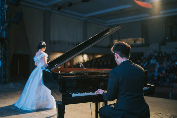 азиатская китайская пианистка играет на рояле с оперной певицей, выступающей соло на сцене - musical band music musical theater classical concert стоковые фото и изображения