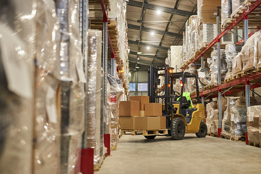 Background image of warehouse interior with forklift carrying boxes, copy space