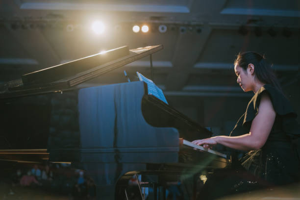 pianista asiática china actuando sola en el escenario con piano de cola - pianist grand piano piano playing fotografías e imágenes de stock