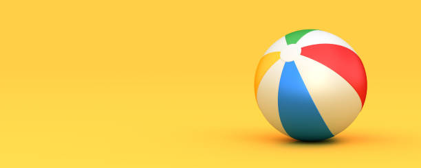 Colorful inflatable beach ball on the yellow background. Summer vacations theme.