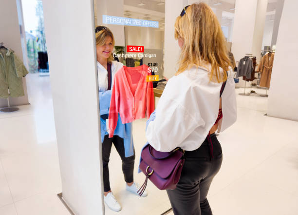 Woman viewing personalized offers on interactive display in retail store stock photo