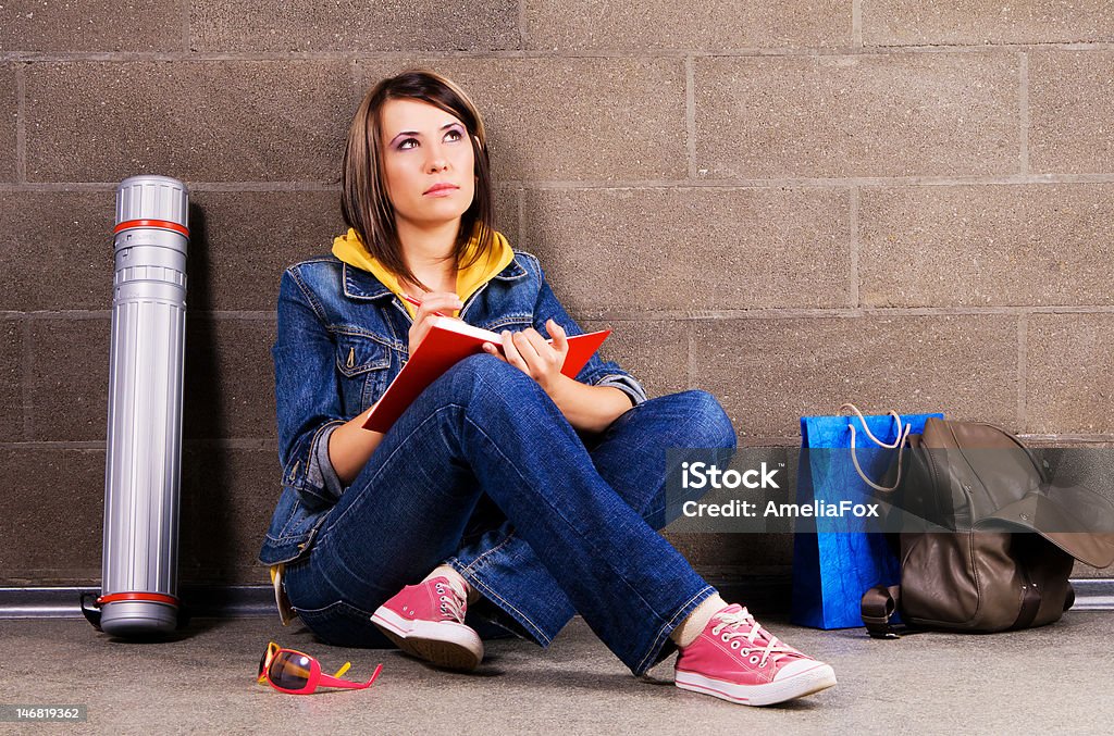 Linda estudante perto da parede, escrevendo no notebook - Foto de stock de Adolescente royalty-free