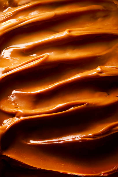 Creamy toffee dulce de leche caramel background texture close up view food art. Curls of caramel. Texture. Creamy toffee dulce de leche caramel background texture close up view food art. Curls of caramel. Texture. dulce de leche stock pictures, royalty-free photos & images