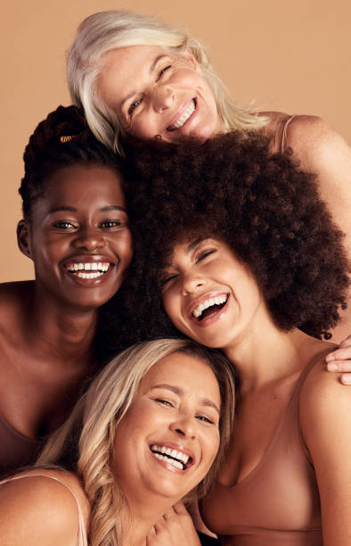 diversità, bellezza e naturale con le amiche in studio su uno sfondo beige per promuovere la cura della pelle. ritratto, viso e sorriso con una donna felice e un gruppo di amici al chiuso per cosmetici di lusso - young adult women african descent 30s foto e immagini stock