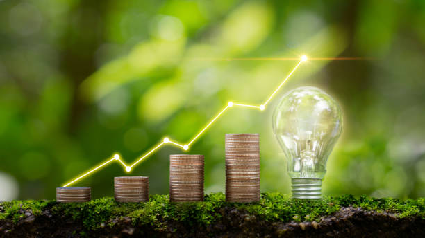 istock Stacked coins and light bulb Renewable energy generation is essential for the future with blurred green natural background. 1468197845