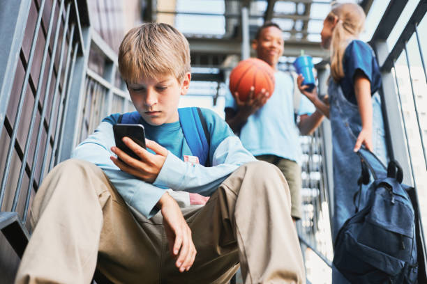 istock Adolescent schoolboy with backpack scrolling in smartphone 1468198621
