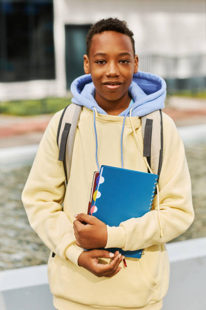 istock Smiling African American schoolboy with copybooks and backpack 1468198749