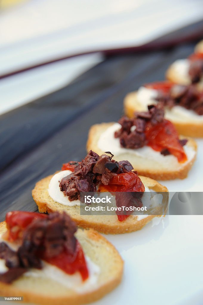 Goat Cheese appetizer Chopped olives and dried tomatoes on goat cheese Appetizer Stock Photo