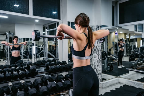 istock Young Woman Lifting Weights In The Gym 1468205587