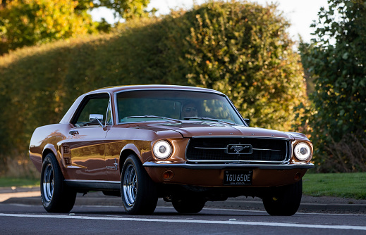Bicester,Oxon,UK - Oct 9th 2022. 1967 Ford mustang classic car driving on an English country road