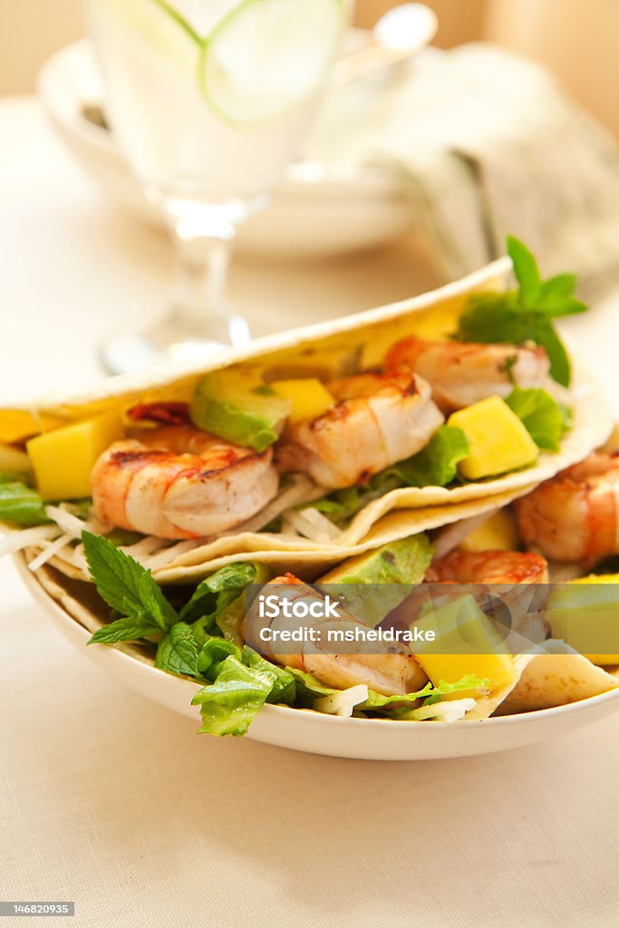 Shrimp Taco Delicious Spicy shrimp taco with lettuce jimaca salad mango and avocado Mango Fruit Stock Photo