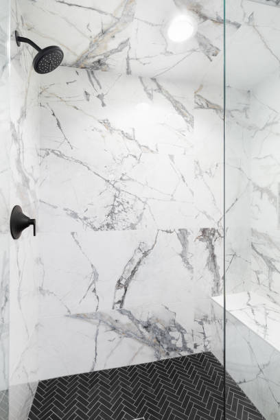 istock A shower with marble tile walls and herringbone tile flooring. 1468209475