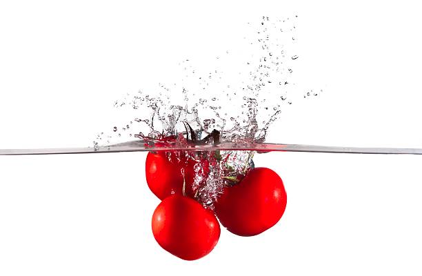Three Red Tomatoes falling into Water Splash stock photo