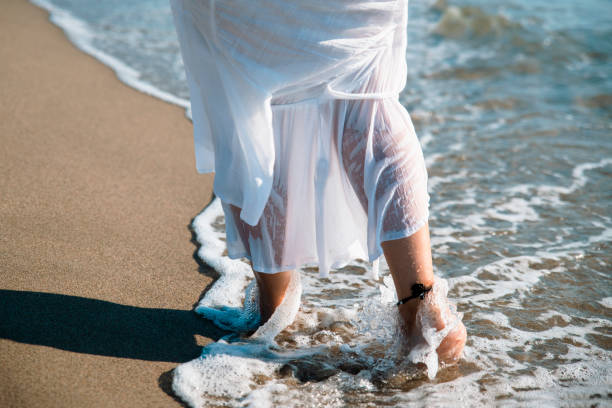 istock Bare female feet in sea water 1468212424
