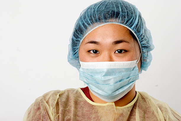 медицинского работника в защитная рабочая одежда - hair net nurse scrubs asian ethnicity стоковые фото и изображения