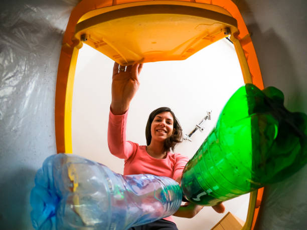istock A young woman puts plastic bottles in the recycling bin 1468217980