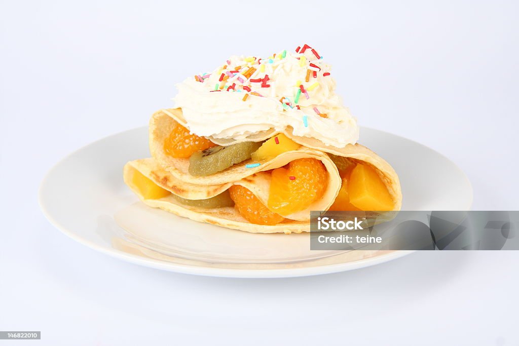 Pancake stuffed with fruit Pancake stuffed with fruit (peach, kiwi, mandarin) with whipped cream and colorful sprinkles Appetizer Stock Photo