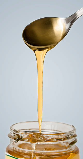 istock Golden honey dropping from spoon in jar 146822075