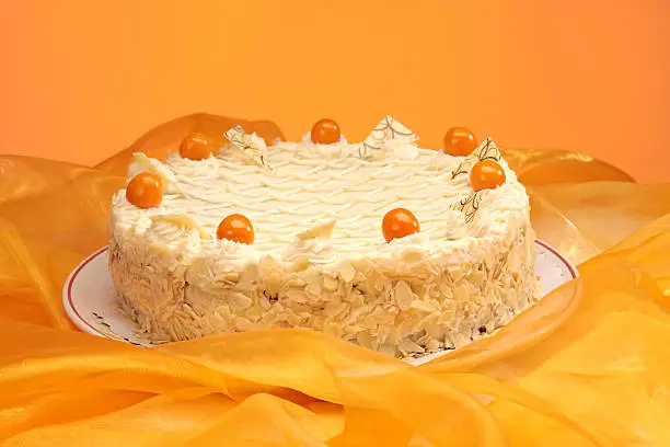 orangecake with cape gooseberry, physalis and almonds, on yellow fabric