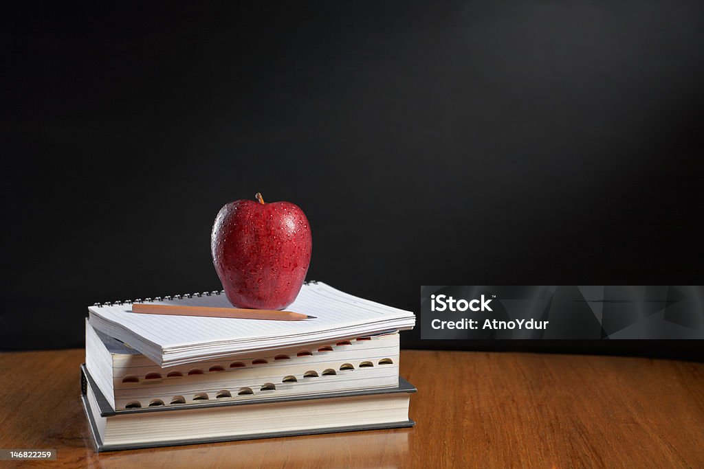 Apple over pile of books Red apple over pile of books for shool concept Apple - Fruit Stock Photo