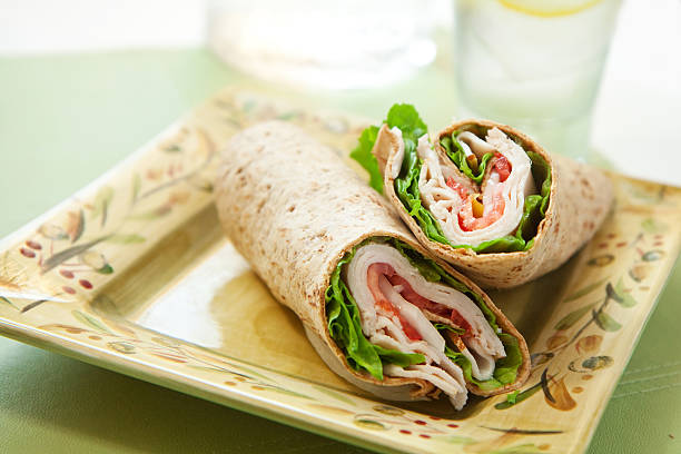 istock Turkey wrap with lettuce and tomatoes on a square plate 146822261
