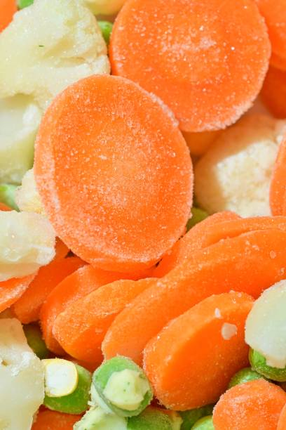 Fresh soup vegetables with carrots, peas, cauliflower and corn on white background. Frozen soup vegetables with carrots, peas, cauliflower and corn. Macro image, close-up. Vertical image. Top view, flat design stock photo