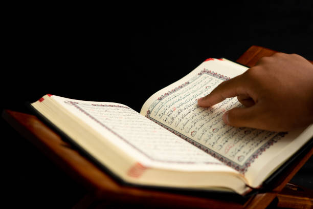 istock praying hands on a Quran book 1468224935
