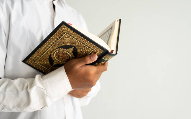 istock person reading the Quran book 1468224937