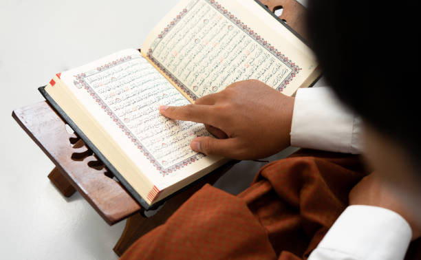 istock person reading holy Quran book 1468224940
