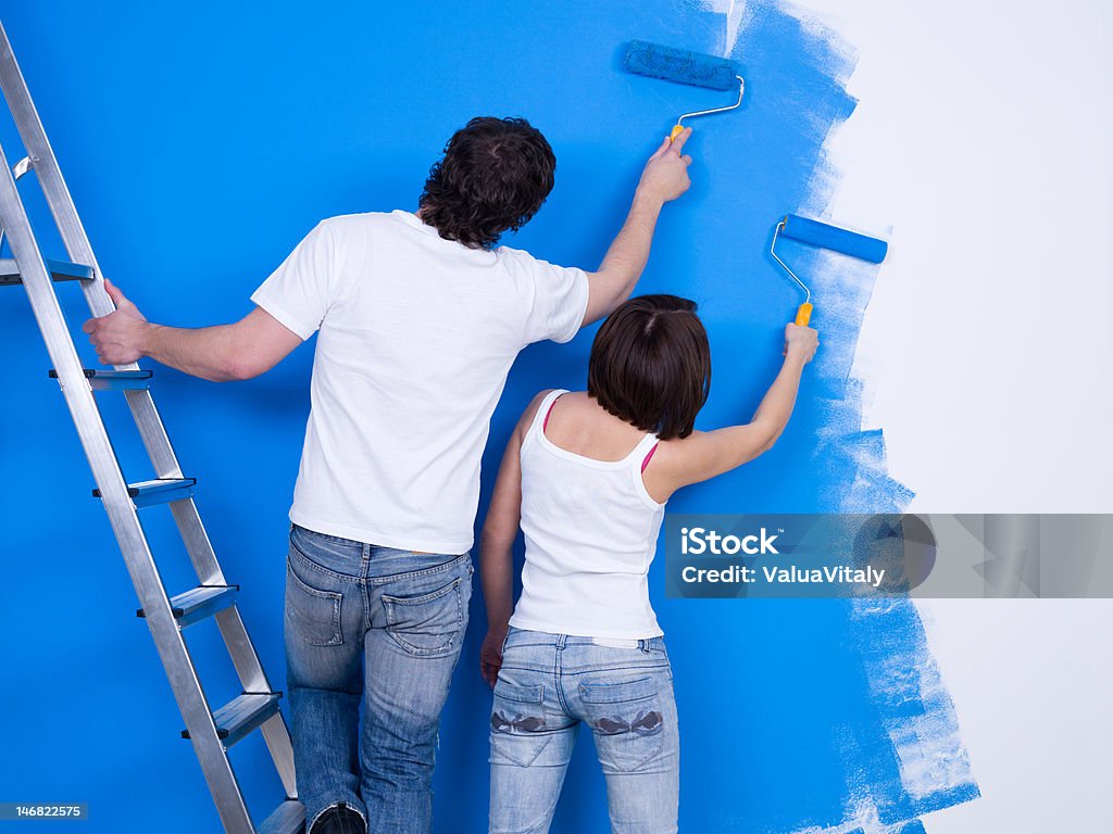 Coppia di persone dipingere il muro - Foto stock royalty-free di Abbigliamento casual