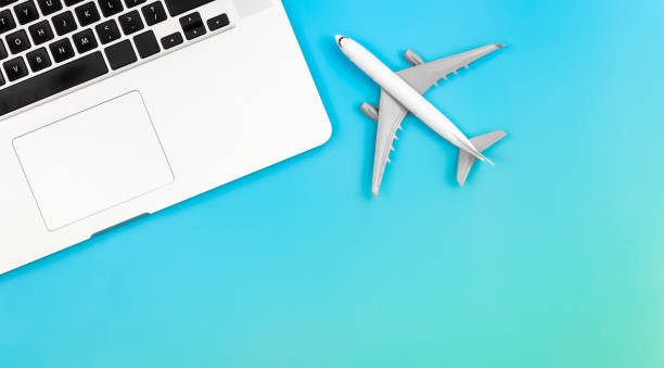istock Laptop and airplane miniature on blue background, flat lay, copy space. 1468227832