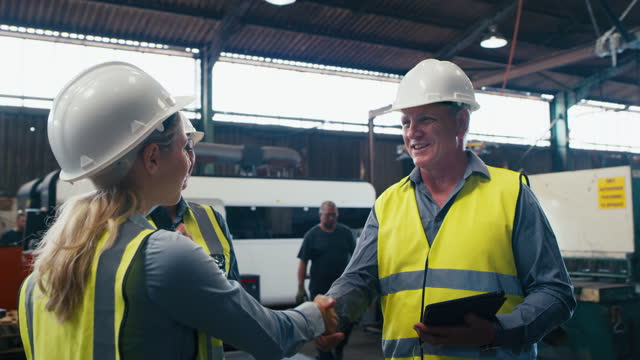 Tablet, engineer handshake and team celebrate factory manufacturing plant, warehouse production or industrial inspection. Engineering teamwork, celebration applause and people with industry success