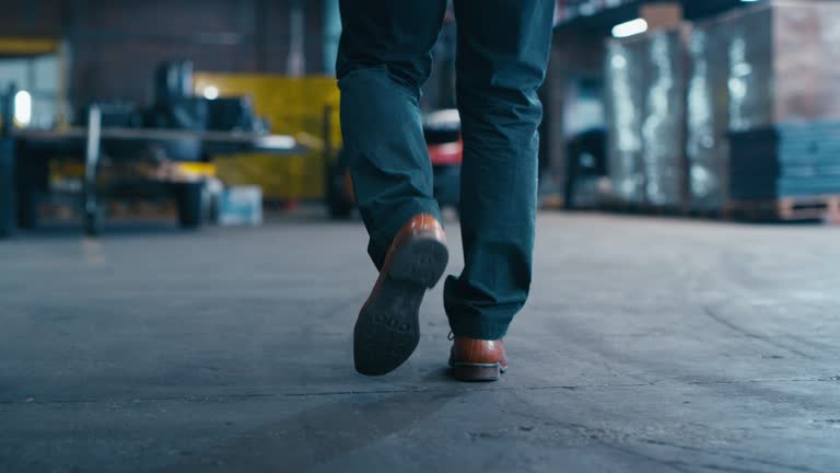 Factory, walking legs or engineer inspection of manufacturing plant, warehouse production or industrial work. Engineering feet, logistics manager shoes or back of industry man planning project design