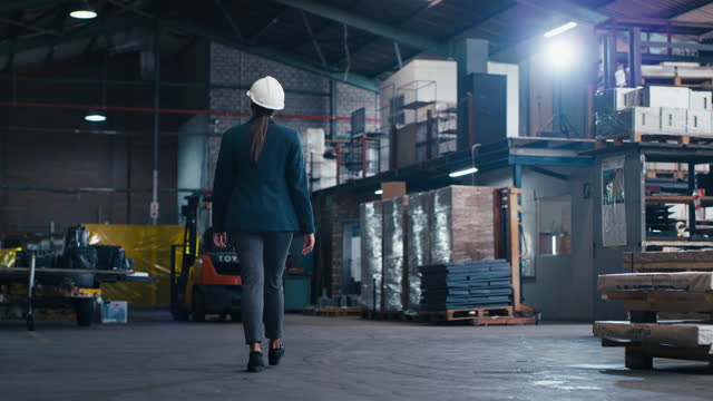 Factory woman, walking or engineer inspection of manufacturing plant, warehouse production or industrial work. Engineering PPE, logistics management or back of industry person planning project design
