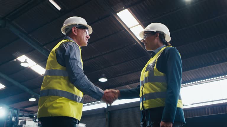 Welcome hand shake, factory and engineering team work on manufacturing plant, production or industrial warehouse. Engineer partnership, below view handshake and industry people talk in communication