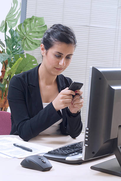 istock businesswoman on office with cell phone 146823100