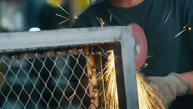 Welder hands, workshop and sparks for welding iron, metal and manufacturing in workshop or warehouse. Industrial worker with grinding tools for professional work or labor in engineering industry