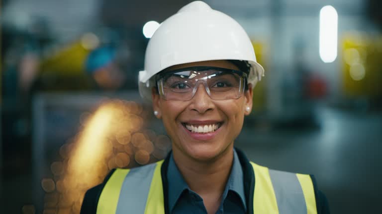 Woman, face and engineer with smile for innovation, vision or automation at manufacturing factory. Portrait of happy female contractor, technician or electrician with safety gear for industrial work