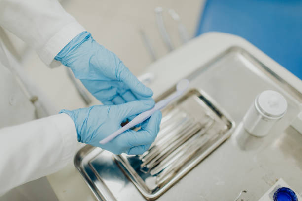 High-angle view close-up of an unrecognizable hand using dentist's instruments stock photo