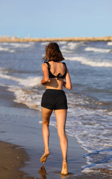 istock girl jogging running on the seashore in summer 1468235603