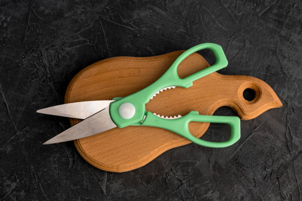 sharp kitchen scissors on a wooden cutting board in the kitchen stock photo